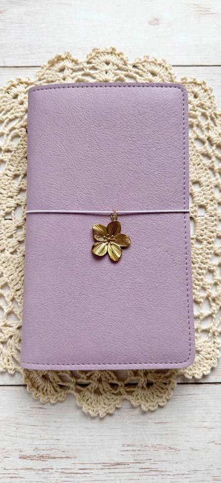 lavender leather journal with white elastic cord and gold flower charm