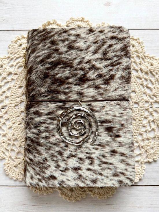 pepper speckled cowhide journal with brown elastic and silver spiral charm