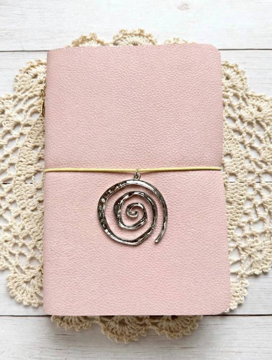 baby pink leather journal with black elastic and silver spiral charm